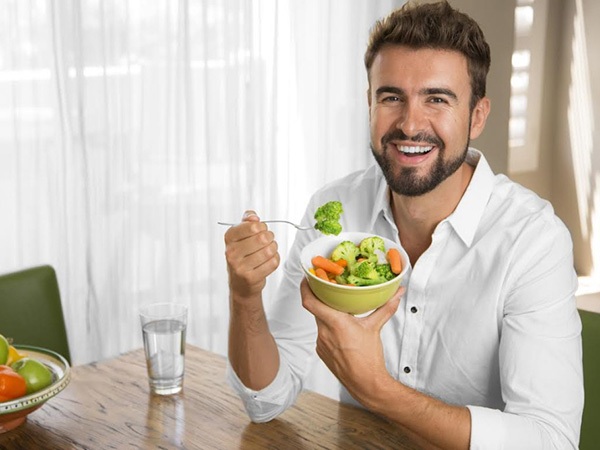 мужчина кушает салат
