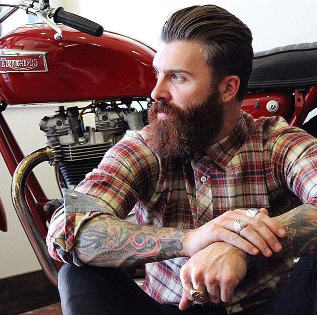 ламберсексуал с татуировками на фоне мотоцикла